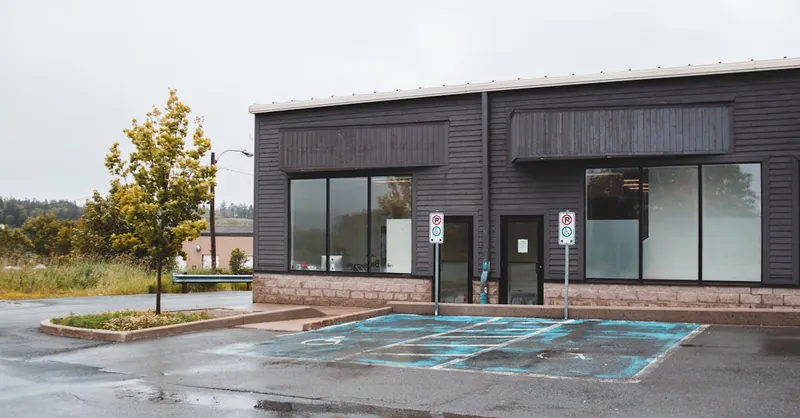 Modern office building with big windows and empty parking lot for people with disabilities