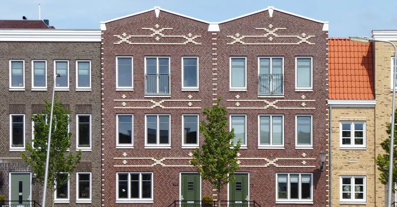 Symmetrical brick residential buildings with intricate geometric facades in a suburban neighborhood.