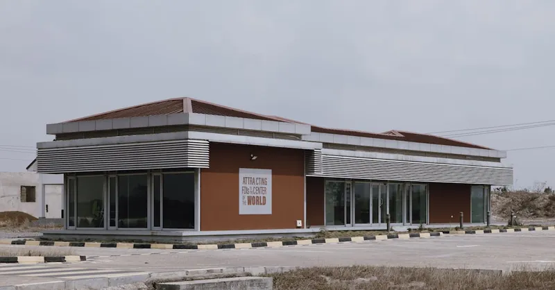 A modern commercial building with reflective glass in a deserted outdoor area.