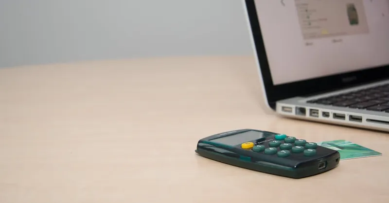 Calculator and laptop on desk symbolize modern financial management and online banking.