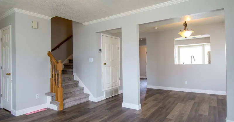 Bright and modern interior of a home with wooden floors and staircase.