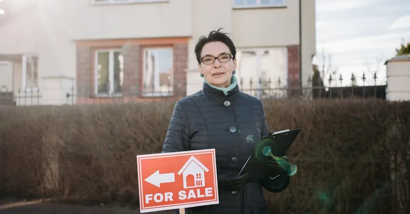 Woman realtor with eyeglasses holding a clipboard and