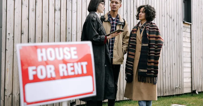 An interracial couple meets with a real estate agent to inquire about a house for rent.